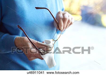 Senior woman cleaning eyeglasses with cloth, mid section View Large Photo Image Stock Image - Senior woman cleaning eyeglasses with cloth, mid section. Fotosearch