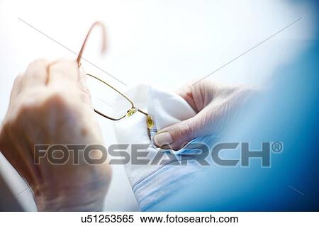 Senior woman cleaning eyeglasses with cloth, mid section View Large Photo Image Stock Photography - Senior woman cleaning eyeglasses with cloth, mid section. Fotosearch