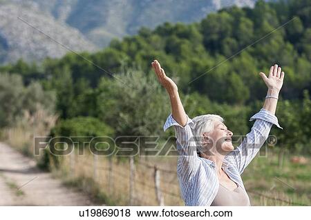 Senior woman, outdoors, arms raised, carefree expression View Large Photo Image Stock Photo - Senior woman, outdoors, arms raised, carefree expression. Fotosearch