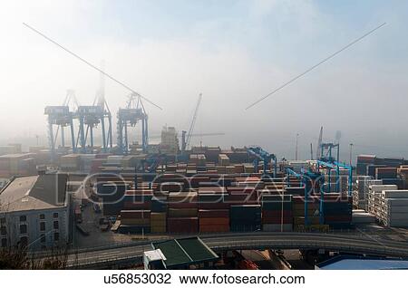 Stock Image - Shipping containers and harbour cranes in mist, Valparaiso, Chile. Fotosearch