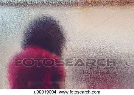 Picture - Silhouette of sad girl behind frosted glass.. Fotosearch
