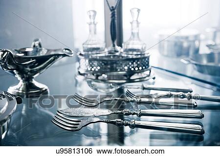Stock Photograph - Silver cutlery, gravy boat and cruet in display cabinet. Fotosearch