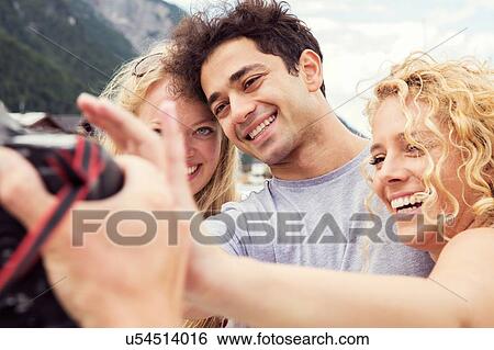 Stock Photograph - Smiling friends posing for photograph. Fotosearch