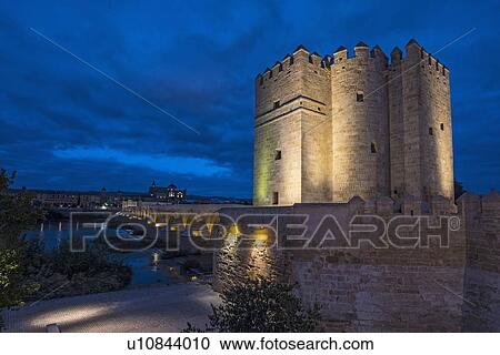 Stock Image - Spain, Andalusia, Cordoba, Illuminated, old church near bridge over Guadalquivir river. Fotosearch