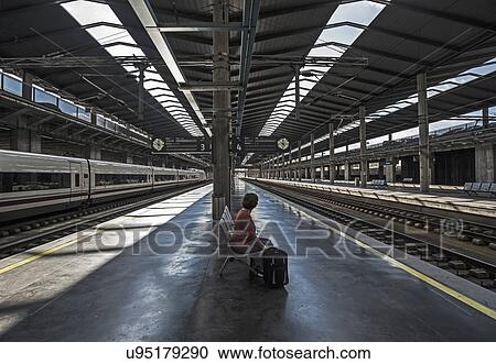 Stock Image - Spain, Andalusia, Cordoba, Woman on empty train platform. Fotosearch