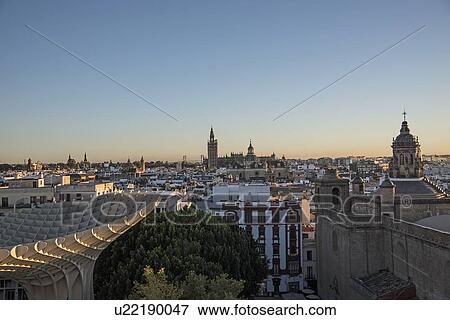 Stock Photo - Spain, Andalusia, Seville, Cityscape in sunlight at dusk seen from Metropol Parasol in Plaza de Encarnacion. Fotosearch