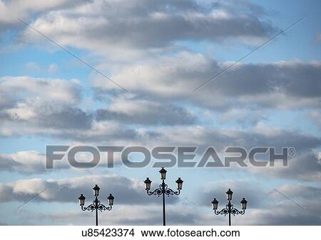 Spain, Andalusia, Seville, Neoclassical style street lights against cloudy sky View Large Photo Image Picture - Spain, Andalusia, Seville, Neoclassical style street lights against cloudy sky. Fotosearch
