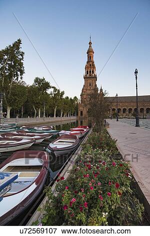 Stock Photo - Spain, Andalusia, Seville, Rowboats moored in canal on Plaza de Espana at dawn. Fotosearch