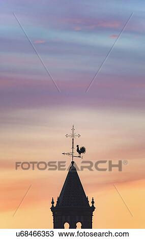 Stock Image - Spain, Andalusia, Seville, Weathercock on top of tower at sunset. Fotosearch