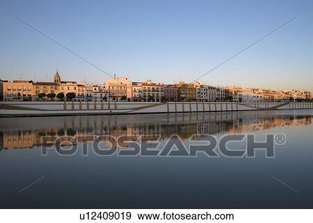 Spain, Seville, Colorful residential building reflecting in Guadalquivir river View Large Photo Image Stock Photo - Spain, Seville, Colorful residential building reflecting in Guadalquivir river. Fotosearch