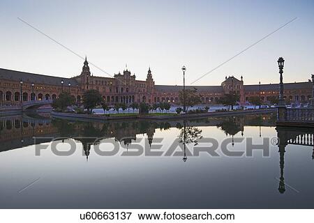 Stock Photo - Spain, Seville, Plaza De Espana reflecting in pond at dawn. Fotosearch