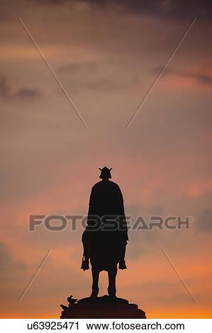 Stock Image - Spain, Seville, Plaza Nueva, Silhouette of equestrian statue of King Fernando III. Fotosearch