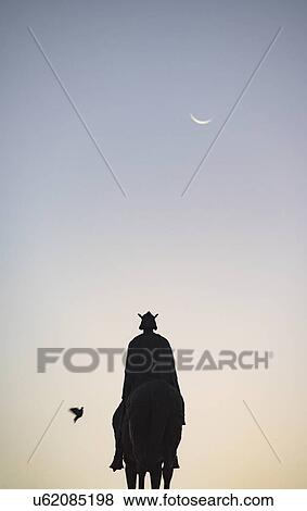 Stock Photo - Spain, Seville, Plaza Nueva, Silhouette of equestrian statue of King Fernando III. Fotosearch