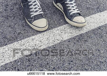 Stock Photo - Standing at a border line, conceptual image.. Fotosearch