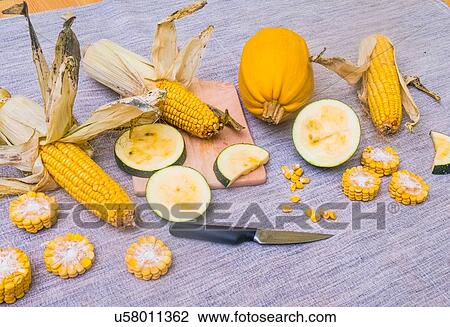 Stock Image - Still life of corn on the cob with two varieties of squash, whole and sliced. Fotosearch