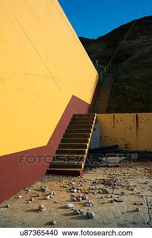 Stock Image - Stones in courtyard, thrown over the sea wall protecting former NATO fuel station. Fotosearch