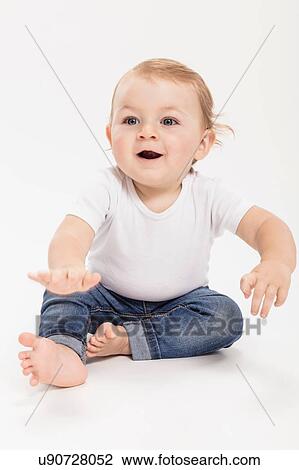 Studio portrait of baby boy sitting on floor View Large Photo Image Stock Image - Studio portrait of baby boy sitting on floor. Fotosearch