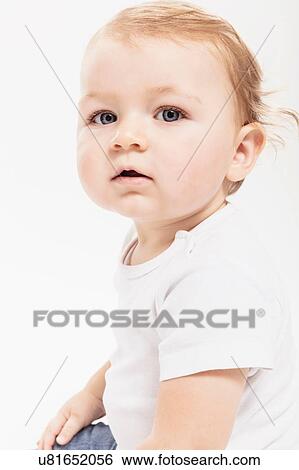 Stock Photograph - Studio portrait of baby boy sitting up, waist up. Fotosearch