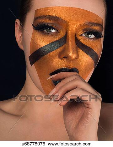 Studio portrait of bare shouldered young woman with bronze on face and black lipstick, close up View Large Photo Image Stock Photograph - Studio portrait of bare shouldered young woman with bronze on face and black lipstick, close up. Fotosearch