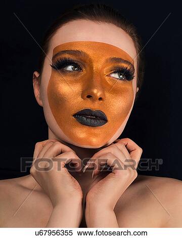 Studio portrait of bare shouldered young woman with bronze on face and black lipstick View Large Photo Image Stock Photography - Studio portrait of bare shouldered young woman with bronze on face and black lipstick. Fotosearch