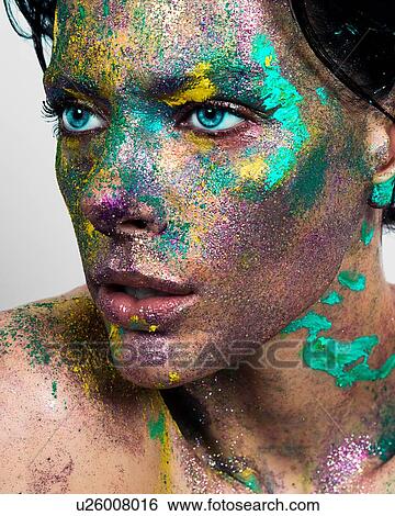 Studio portrait of blue eyed young woman with glittery multi coloured powder on face View Large Photo Image Stock Photograph - Studio portrait of blue eyed young woman with glittery multi coloured powder on face. Fotosearch