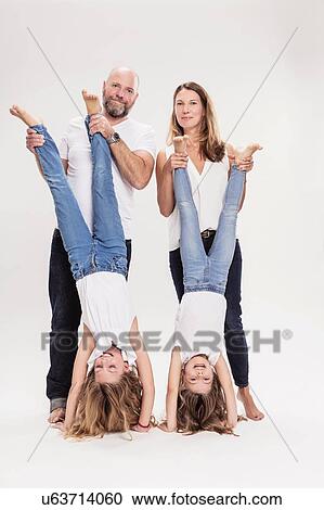 Studio portrait of mature couple with two daughters doing hand stands, full length View Large Photo Image Stock Image - Studio portrait of mature couple with two daughters doing hand stands, full length. Fotosearch