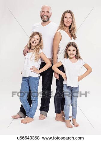 Stock Photo - Studio portrait of mature couple with two daughters, full length. Fotosearch