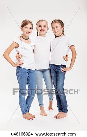 Picture - Studio portrait of three girls posing with hands on hips. Fotosearch