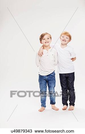 Stock Image - Studio portrait of two boys, full length. Fotosearch