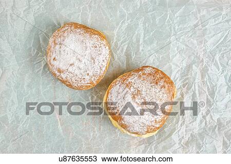 Stock Image - Sugary donuts on baking paper.. Fotosearch