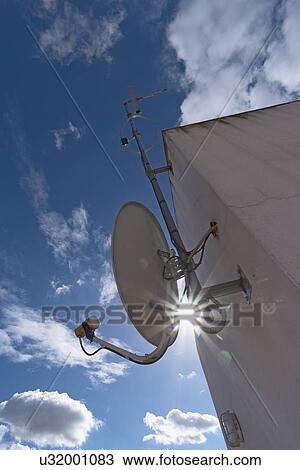 Sun shining through space between satellite dish and facade View Large Photo Image Stock Image - Sun shining through space between satellite dish and facade. Fotosearch
