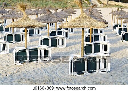 Stock Photo - Sunbeds and umbrellas on sandy beach.. Fotosearch