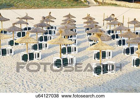 Stock Photo - Sunbeds and umbrellas on sandy beach.. Fotosearch