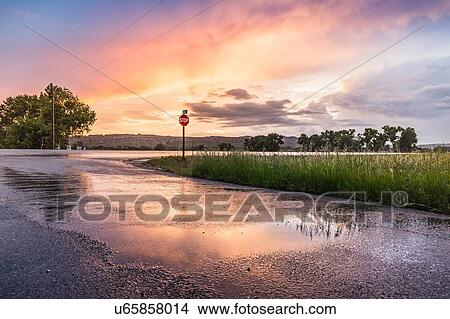 Picture - Sunset reflected on wet highway, Montana, US. Fotosearch