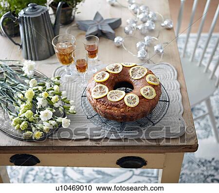 Stock Image - Table with bundt cake, flowers and drinks. Fotosearch