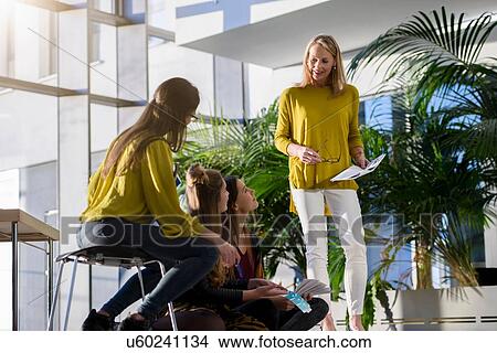 Picture - Team of female designers discussing colour swatches in design studio. Fotosearch