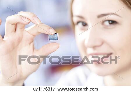 Stock Photo - Technician examining microchip in microelectronics laboratory.. Fotosearch