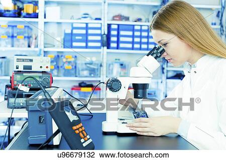 Technician using microscope to examine microelectronics. View Large Photo Image Stock Image - Technician using microscope to examine microelectronics.. Fotosearch