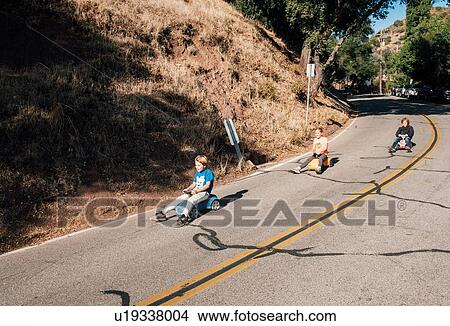 Picture - Three children, rolling downhill of toy cars. Fotosearch