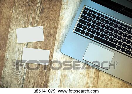 Stock Photo - Top view of laptop and blank business cards on desk.. Fotosearch