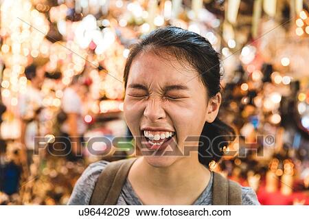 Stock Photo - Tourist laughing in bazaar, Bangkok, Thailand. Fotosearch