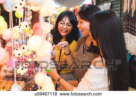 Stock Photo - Tourists admiring decorative lights in bazaar, Bangkok, Thailand. Fotosearch