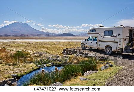 Stock Photo - Two boys playing in water pool beside parked recreational vehicle, Salar de Chiguana, Chiguana, Potosi, Bolivia, South America. Fotosearch