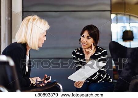 Two businesswomen in meeting, looking at document View Large Photo Image Stock Photo - Two businesswomen in meeting, looking at document. Fotosearch