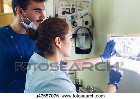 Stock Photograph - Two dentists in dentist office, looking at dental x-ray. Fotosearch