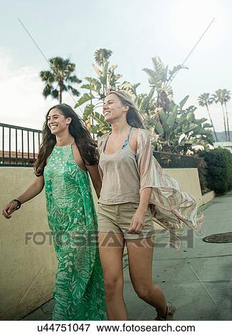 Two female friends, walking outdoors View Large Photo Image Stock Photo - Two female friends, walking outdoors. Fotosearch