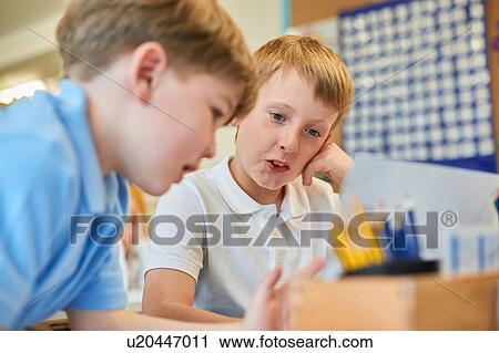 Two schoolboys problem solving in classroom at primary school View Large Photo Image Stock Image - Two schoolboys problem solving in classroom at primary school. Fotosearch