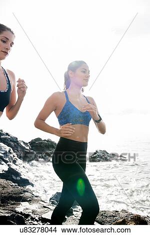 Picture - Two young female runners running on beach, Las Palmas, Canary Islands, Spain. Fotosearch
