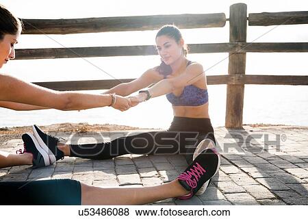 Two young women training together on sea waterfront View Large Photo Image Stock Photo - Two young women training together on sea waterfront. Fotosearch