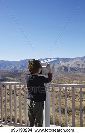 Picture - USA, Arizona, Boy (6-7) looking through coin operated binoculars. Fotosearch